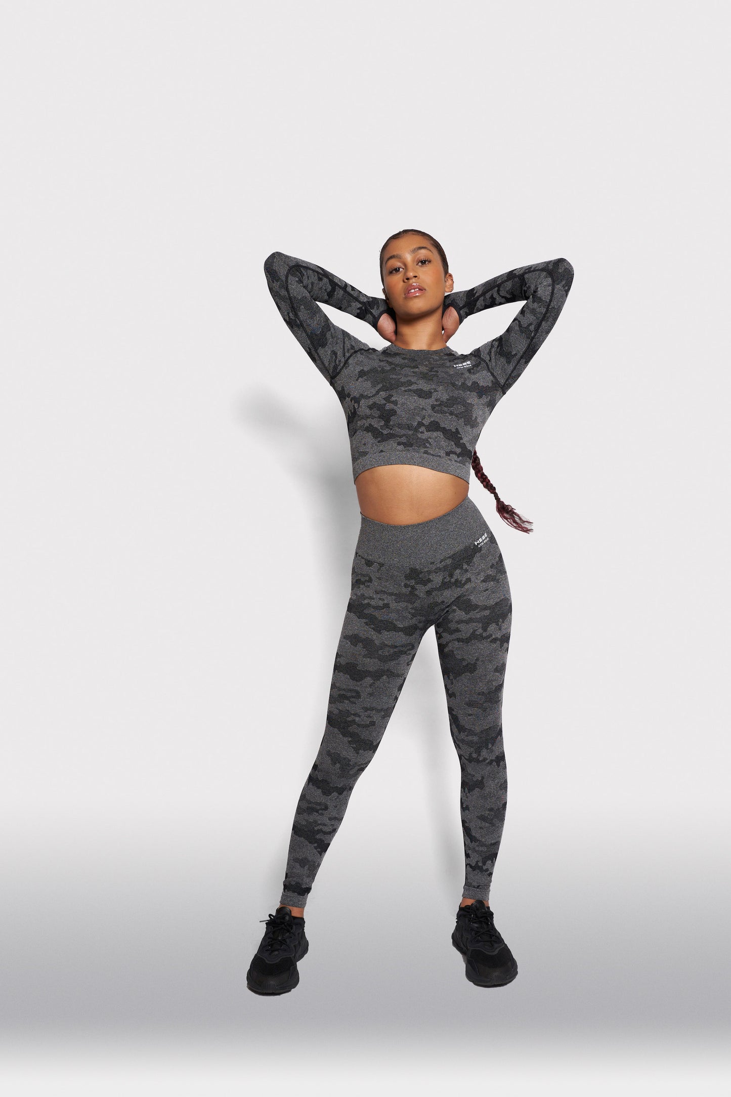 woman posing in matching grey camouflage gym wear